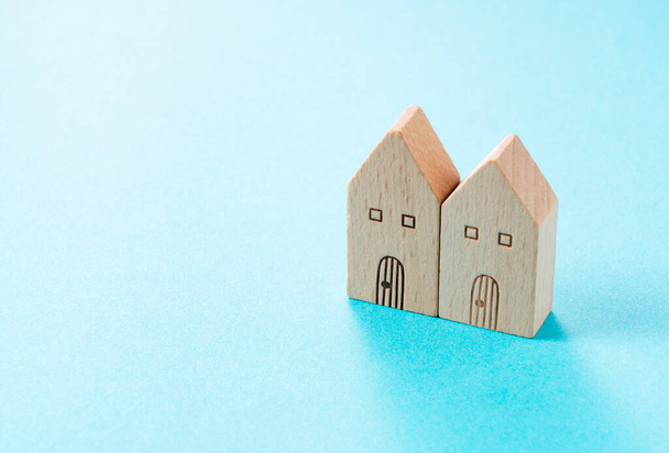 Casa de juguete hecha de madera colocada sobre un fondo azul con espacio para copiar - Foto, Imagen