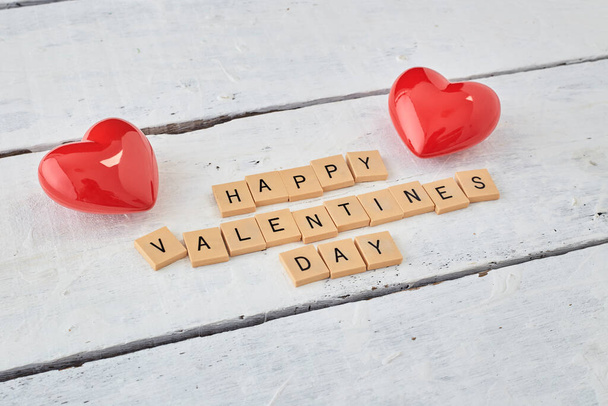 Rode harten met Valentijnsdag tekst op hout witte achtergrond - Foto, afbeelding