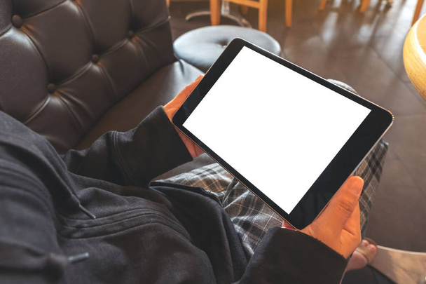 Mockup kép egy nő kezében fekete tabletta pc üres fehér képernyő vízszintesen, miközben ül a kávézóban - Fotó, kép
