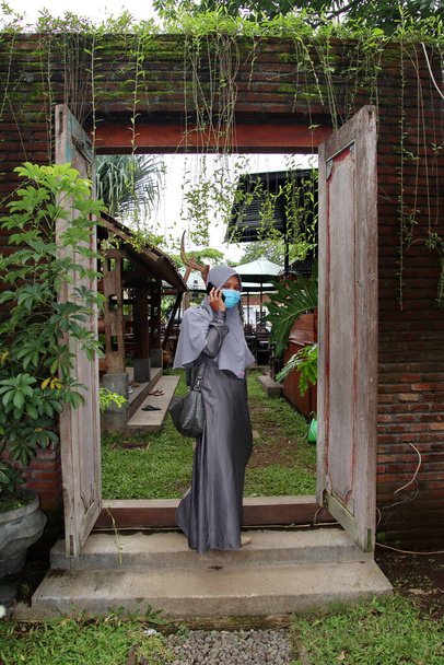  Krásné ženy nosí hidžáb a masku, při relaxaci v chladné kavárně, Selektivní zaměření a hluk image - Fotografie, Obrázek