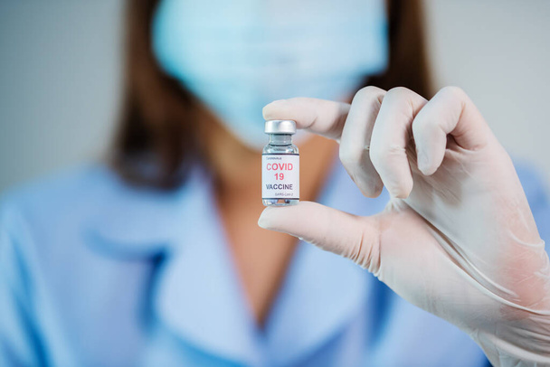 female doctor holding Coronavirus (Covid-19) vaccine bottle for injection medicine - 写真・画像