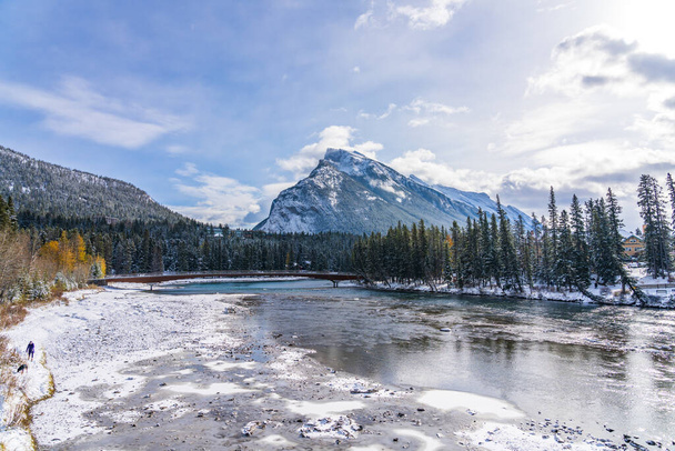 Park Narodowy Banff piękny krajobraz, pokryty śniegiem Mount Rundle, dryfujący lód unoszący się na Bow River w zimie. Canadian Rockies, Alberta, Kanada. - Zdjęcie, obraz