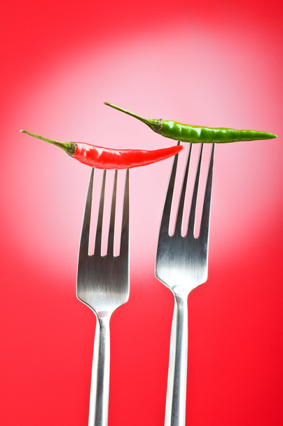 Pimienta picante en el tenedor contra fondo de color
 - Foto, imagen