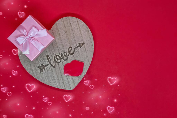 Valentine's day concept, love lettering on wooden heart, gift box, red background. - Photo, Image