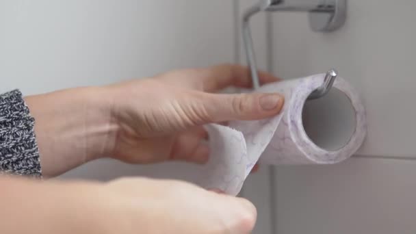 La persona rebobina un pedazo de papel higiénico y rasga - Imágenes, Vídeo
