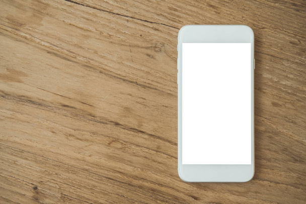 Εικόνα mockup από λευκό κινητό τηλέφωνο με λευκή οθόνη σε vintage ξύλινο τραπέζι φόντο - Φωτογραφία, εικόνα