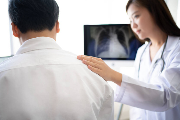 Ázsiai női orvos bátorító vizsgálat és röntgen a beteg. - Fotó, kép