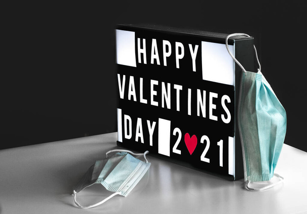 Feliz día de San Valentín 2021 signo a bordo con 2 máscaras - Foto, Imagen