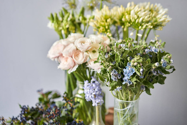 Conjunto de flores blancas y azules para la decoración de interiores. El trabajo de la floristería en una florería. Flor recién cortada. Tienda floral europea. Entrega flor fresca cortada - Foto, imagen
