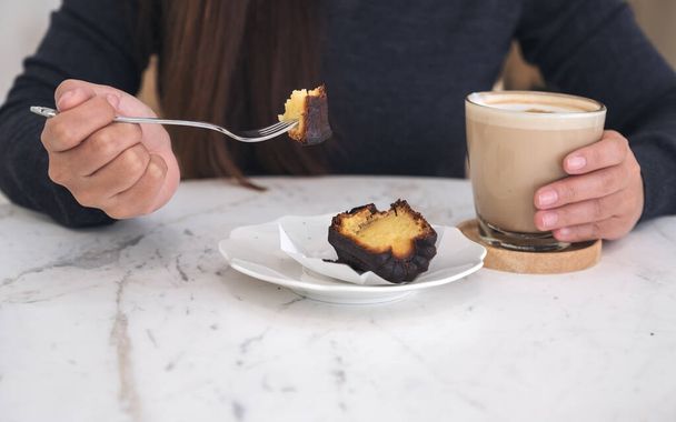 フォークで食べる手摘みデザートとカフェでテーブルの上のコーヒーカップ - 写真・画像