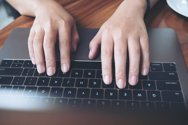 Εικόνα πάνω όψης των χεριών μιας γυναίκας επιχείρησης που εργάζονται και πληκτρολογούν στο πληκτρολόγιο laptop  - Φωτογραφία, εικόνα