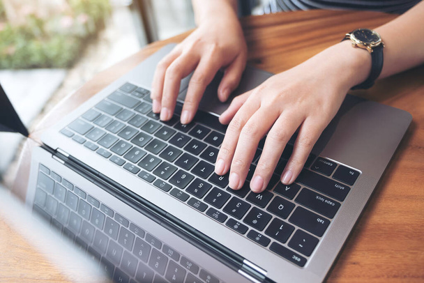 Top view beeld van de handen van een zakenvrouw werken en typen op laptop toetsenbord  - Foto, afbeelding