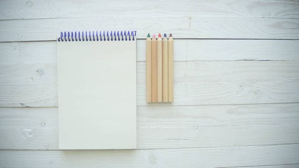 Blanko-Notizbuch auf braunem Holztischhintergrund. Draufsicht mit Kopierraum (selektiver Fokus). Bürotischkonzept - Foto, Bild
