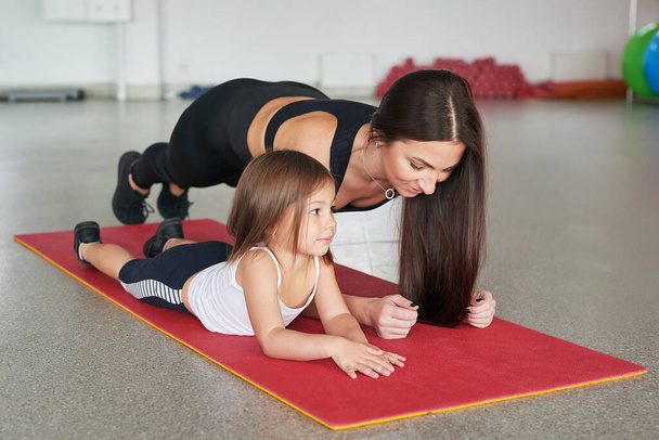 Fitness mother and child. Sports activities with children. Fitness center. Mom and baby gymnastics, yoga exercises. Health and sport concept. Family individual training. - Photo, Image