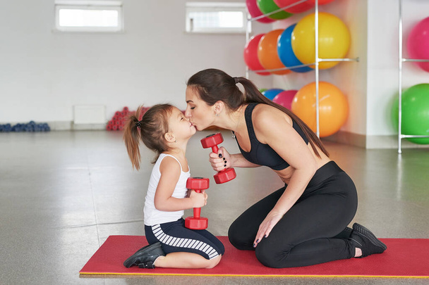 Fitness mother and child. Sports activities with children. Fitness center. Mom and baby gymnastics, yoga exercises. Health and sport concept. Family individual training. - Fotoğraf, Görsel