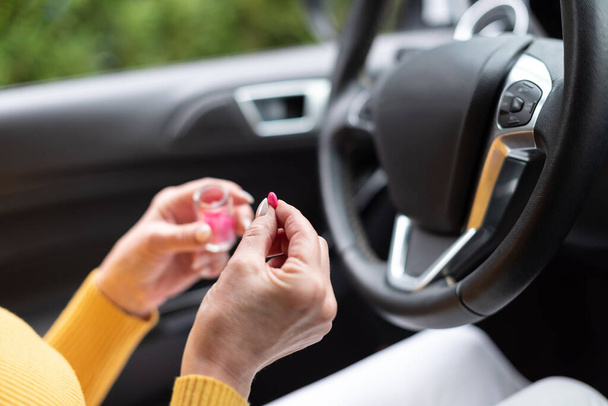 Femme assise en voiture et prenant des pilules avant de conduire - Photo, image