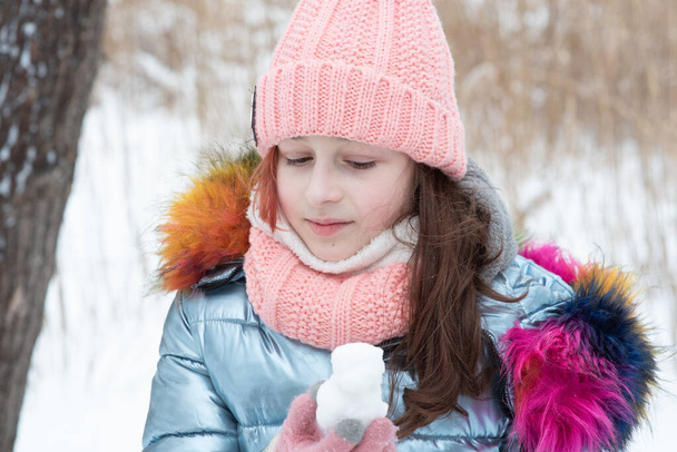 Зимний портрет молодой девушки в теплой одежде. Девочка-подросток в шляпе в снежную погоду. Снег - Фото, изображение