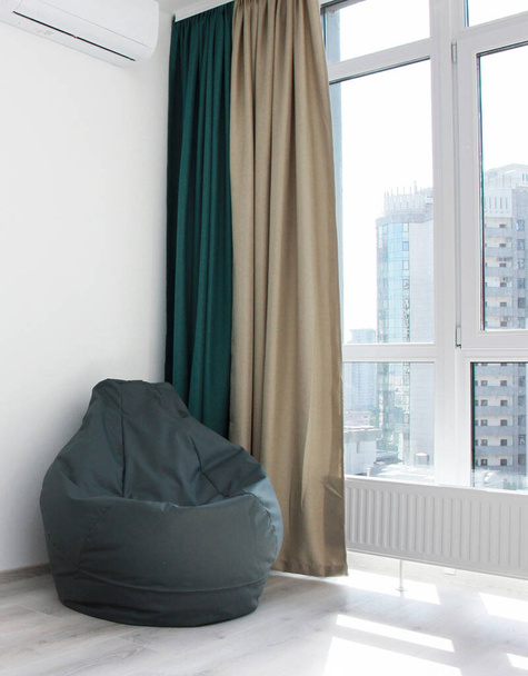 frameloze grijze fauteuil bij het raam Scandinavisch design, slaapkamers, interieur, minimalisme - Foto, afbeelding