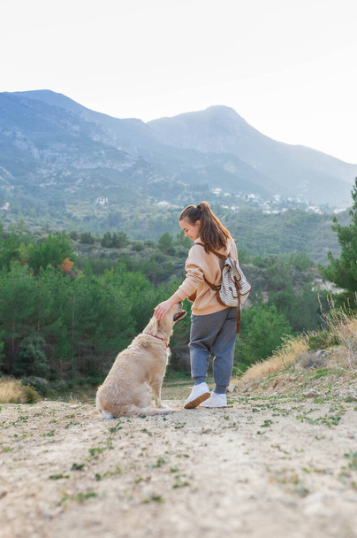 девочка с золотой собакой-ретривером в горах. Осеннее настроение. Путешествует с домашним животным. Новая концепция реальности путешествий. Домашние животные и человеческие отношения - Фото, изображение