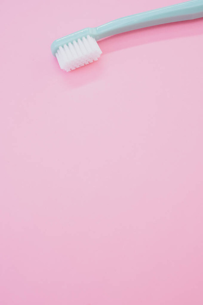 A vertical shot of a simple toothbrush isolated on a pink background - Foto, Bild