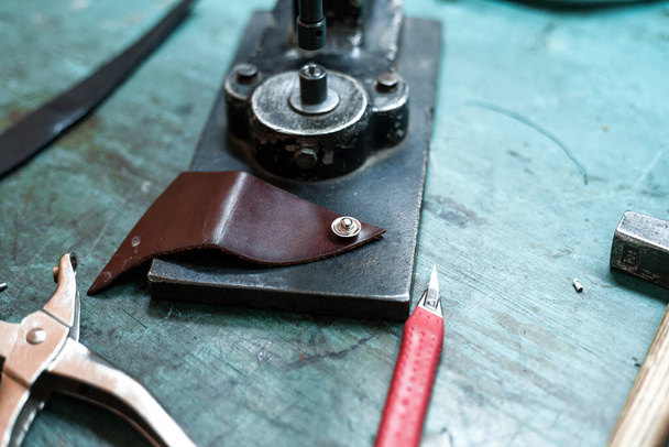 A closeup shot of leather tools on a craftsman table - Fotó, kép