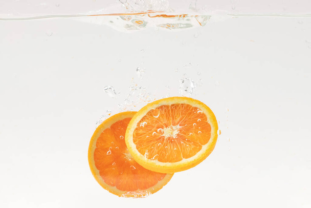 Orange slices bubbling in water - Foto, afbeelding