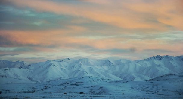 A mesmerizing shot of beautiful snow-capped mountains at scenic sunset - Φωτογραφία, εικόνα