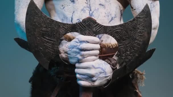 Злой северный викинг держит топор двумя руками на синем фоне. - Кадры, видео