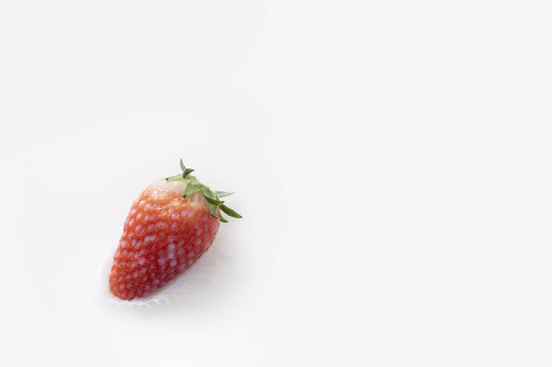 A high angle shot of a strawberry floating in some milk - Valokuva, kuva