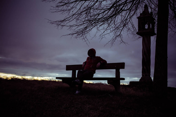 silhouet van een mysterieuze hacker, eenzame anonieme man zittend op een bank  - Foto, afbeelding