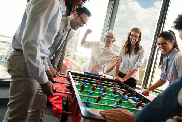 Coworkers playing table football and relaxing on break from work - Foto, Bild