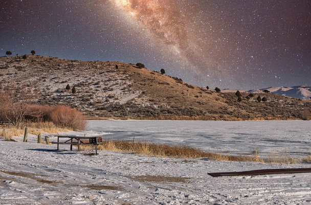 A snow-covered landscape under a mesmerizing starry sky - Foto, Bild