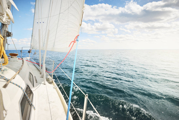 Біла яхта пливе у сонячний день. Вгорі вниз, від палуби до лука і вітрил. Хвилі та вода бризкають. Чисте блакитне небо. Північне море, Норвегія. Транспорт, спорт, рекреаційна тема - Фото, зображення