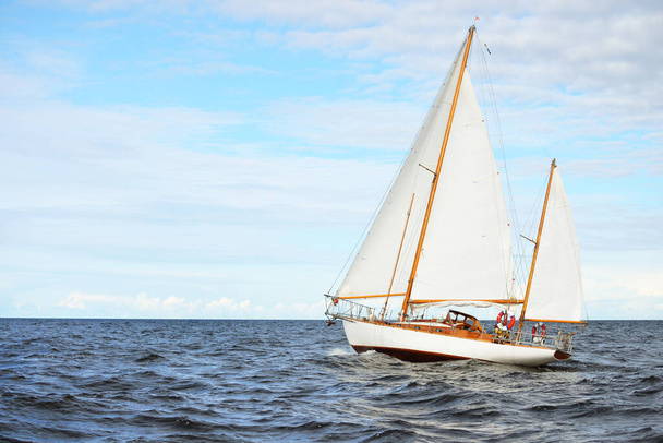 Oude dure vintage houten zeilboot (yawl) close-up, zeilen in een open zee. Prachtig wolkenlandschap. Kust van Maine, VS - Foto, afbeelding