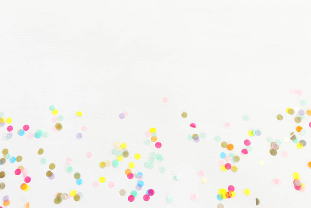 Party colorful confetti over white wooden background . Top view, flat lay - Photo, Image