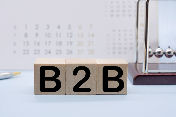 Процесс успеха бизнес-концепции. Деревянный блок с b2b, колыбель и калькулятор Ньютона - Фото, изображение