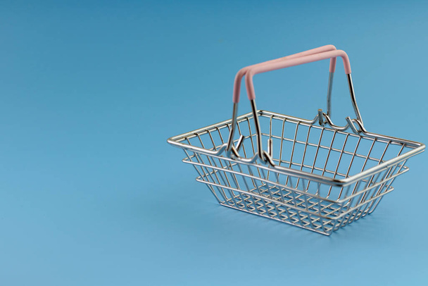 small shopping cart on turquoise background, copy space, shopping concept - Photo, Image