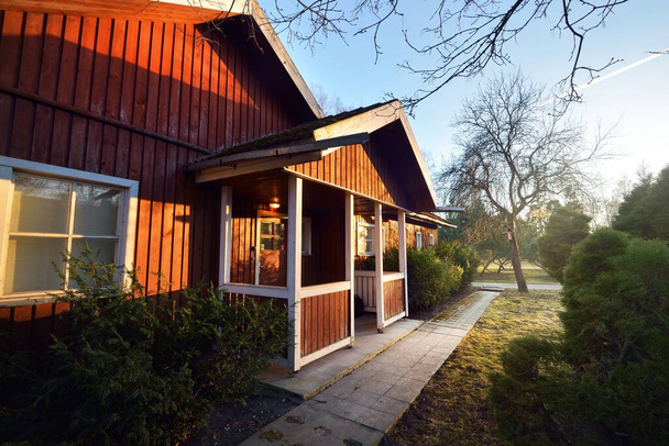 美しい庭にタイルの屋根を持つ赤い素朴な木造の家の景色。人々は旅行禁止のために家にいる。コロナウイルス(COVID-19)の発生,スウェーデンの検疫区域 - 写真・画像