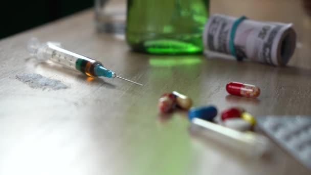 syringe with heroin cocaine and pills standing on the table after a party. bad habits and drug addiction concept - Footage, Video