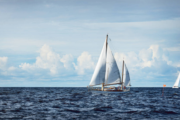 Oude dure vintage houten zeilboot (yawl) close-up, zeilen in een open zee. Dramatisch wolkenlandschap. Kust van Maine, VS - Foto, afbeelding
