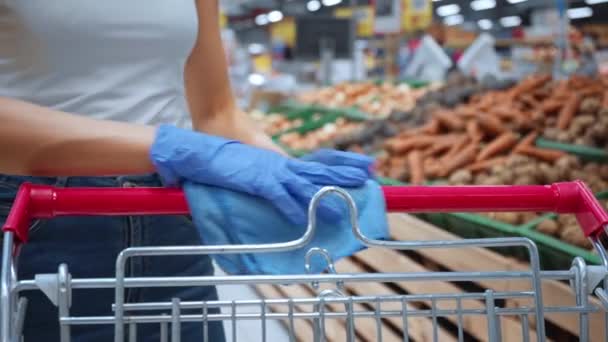 Teilansicht einer Frau, die Desinfektionsmittel auf Einkaufswagen in Einkaufszentrum sprüht - Filmmaterial, Video