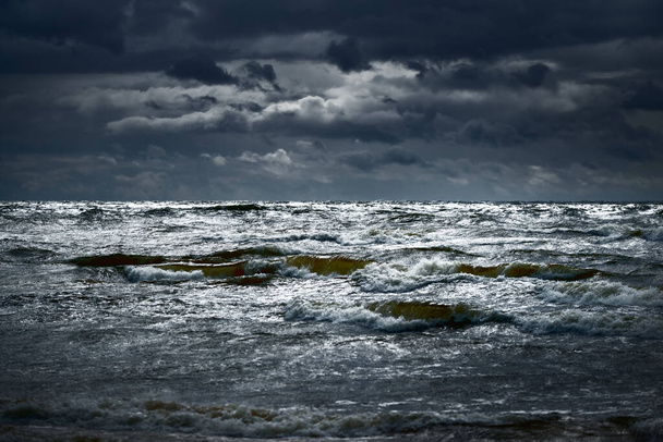 雷雨の後、暗い劇的な雲の下でバルト海。ラトビア。壮大な海の景色。サイクロン、強風、嵐、荒天、気象学、生態学、気候変動、自然現象 - 写真・画像