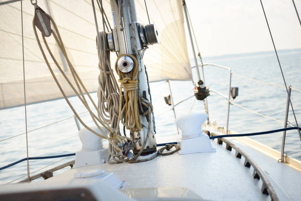Valkoinen jahti avomerellä kirkkaana päivänä. Näkymä kannelta keulaan, masto ja purjeet, takila laitteet lähikuva. KesäAtlantti purjehdus Espanjan ja Afrikan lähellä - Valokuva, kuva