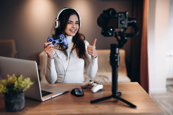 Hezký blogger žena ve sluchátkách je streaming živě mluvit o videohrách. Influencer mladá žena živé streamování. - Fotografie, Obrázek