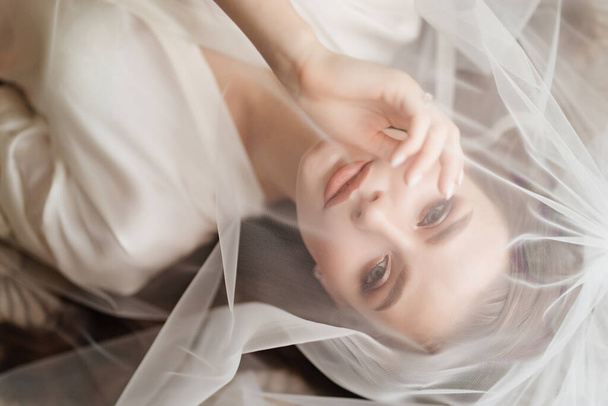 view top. a beautiful young woman in robe is lying under a veil. - Foto, immagini