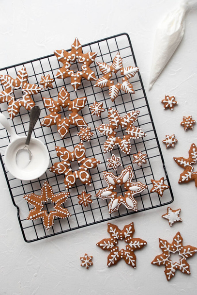 gingerbread cookies on a metal baking rack, decorating cookies with frosting,New Yea`rs atmosphere - Fotó, kép