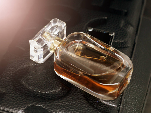 Brown perfume glass on a women leather bag so close - Fotoğraf, Görsel