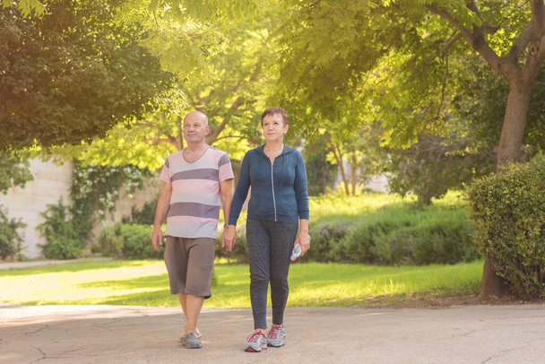 Family, age, sport, healthy and people concept - happy senior couple holding hands and exercising together. - Foto, Bild