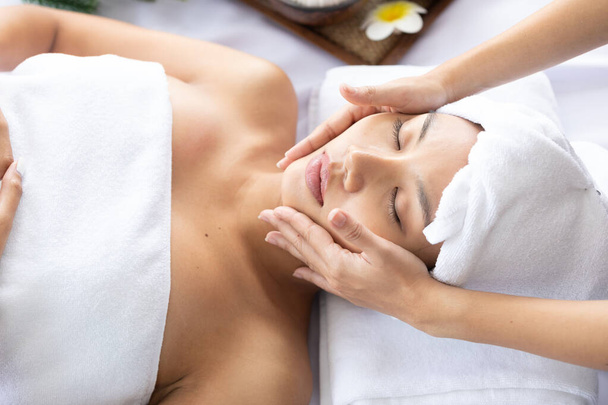 young asian beautiful woman getting facial treatment and enjoying massage in spa salon - Фото, изображение