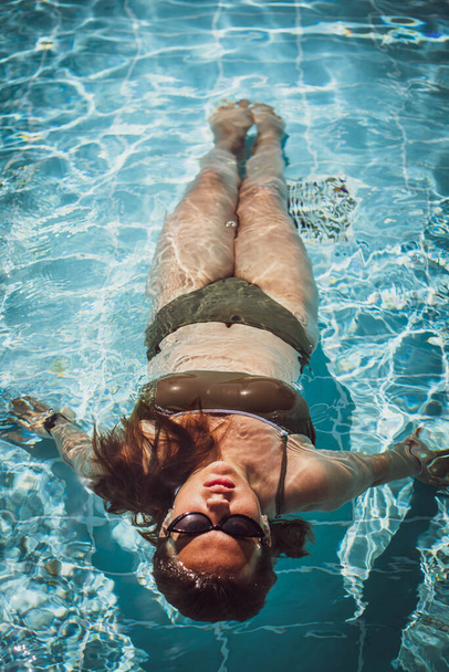 Moda portret wdzięku słodkie dziewczyny w stylowych okularach przeciwsłonecznych pozowanie w basenie podczas wakacji na luksusowym kurorcie. Wesoły plus rozmiar nastolatka cieszy. radosne, pozytywne emocje, letni styl. - Zdjęcie, obraz